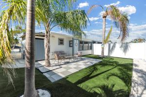 a yard with palm trees and a house at Beach Getaway on Anna Maria Island in Holmes Beach