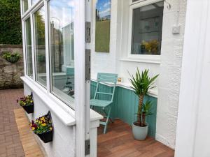 a small porch with a chair and a window at Hollybank in Ladybank +6 photos