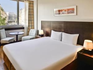 a hotel room with a large bed and a chair at Aparthotel Adagio Genève Mont-Blanc in Geneva