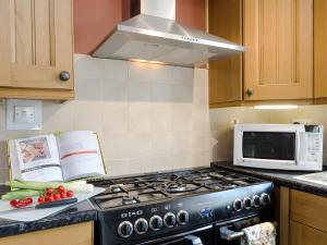 a kitchen with a stove and a microwave at Lillegarth in Bradwell