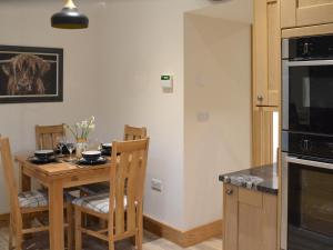 a kitchen with a wooden table with chairs and a counter at Chancer in Newlyn