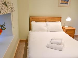 a bedroom with a white bed with a stack of towels at Chancer in Newlyn +11 photos