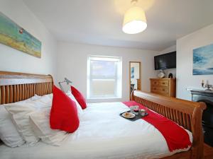 a bed with red pillows and a tray on it at Dreamers View in Margate +11 photos