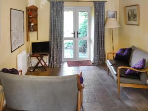 ein Wohnzimmer mit Sofa und Fernseher in der Unterkunft Bear Cottage in Abbey Dore + 10 Fotos