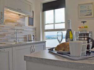 a kitchen counter with a plate of bread and a bottle of wine at Sea View Sanctuary in Scarborough