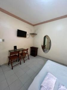 a room with a table and a mirror and a bed at Hotel Fênix in Salvador