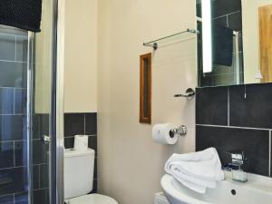a bathroom with a toilet and a sink and a mirror at Ardennes Cottage in Sewerby +9 photos