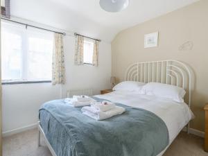 a bedroom with a bed with two towels on it at Cross Cottage in Saint Breward