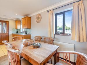 une cuisine et une salle à manger avec une table et des chaises en bois dans l'établissement Chestnut Cottage - Uk45580, à Maltby le Marsh