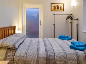 a bed with two blue pillows on top of it at Fisherman's Cottage in Sheringham