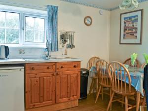 a kitchen with a sink and a table with chairs at Eleven in Bude