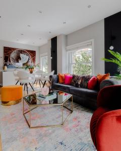 a living room with a black couch and a table at Cool Covent Garden Theatre Design Hub for Families Friends Couples in London