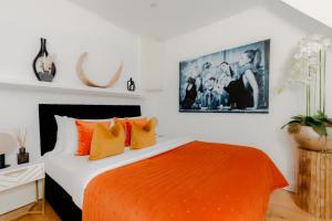 a bedroom with a bed with an orange blanket at Cool Covent Garden Theatre Design Hub for Families Friends Couples in London