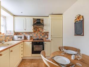 a kitchen with white cabinets and a wooden table at The Dairy - Uk37518 in Routh