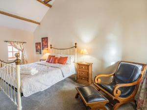 a bedroom with a bed and a chair at The Dairy - Uk37518 in Routh +9 photos