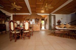 a living room with a couch and a table and chairs at La Digue Emerald Villa in La Digue