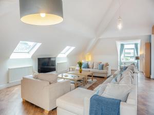 a living room with two couches and a table at The Penthouse in Morfa Nefyn