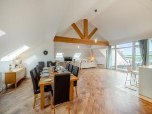 a dining room and living room with a table and chairs at The Penthouse in Morfa Nefyn
