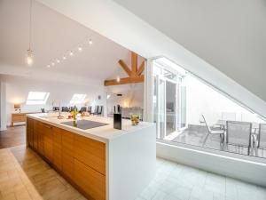 an attic kitchen with a large window and a dining room at The Penthouse in Morfa Nefyn