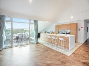 a kitchen with a counter with stools at The Penthouse in Morfa Nefyn