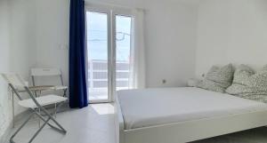 a white bedroom with a bed and a window at Residência Alto Saco - Double Room with Shared Bathroom - Tarrafal de São Nicolau in Tarrafal