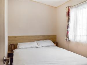 a bedroom with a white bed and a window at Cara in Lancaster