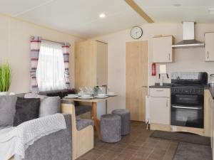 a kitchen and living room with a couch and a table at Cara in Lancaster