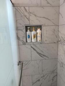a shelf in a bathroom with four bottles on it at Emmanuel Fulton Park Condominium in Tulsa