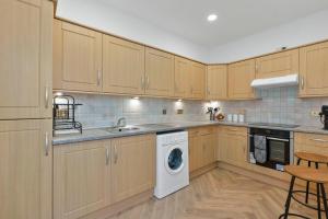 a kitchen with wooden cabinets and a washing machine at The Barony Fox in Edinburgh +12 photos
