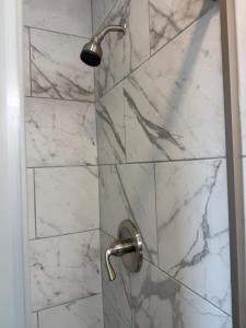 a bathroom with a shower with marble tiles at Emmanuel Fulton Park Condominium in Tulsa +24 photos