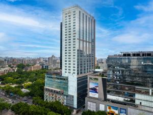 Un haut gratte-ciel blanc dans une ville dans l'établissement JunHome International Apartment-Beijing Rd A-mall, à Canton