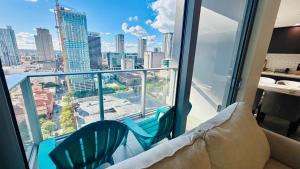 a balcony with two chairs and a view of a city at Rare Corner Unit Private Terrace & Sunset Views in Miami