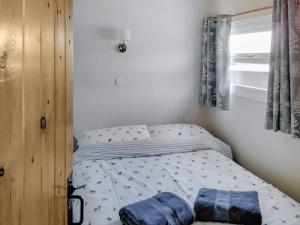 1 dormitorio pequeño con 1 cama con sábanas azules en Blue Skies - 30260, en Cromer