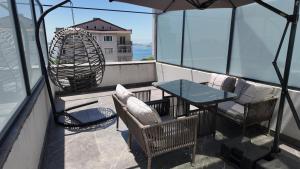 uma varanda com mesa, cadeiras e um guarda-sol em The Port Güzelyalı em Pendik