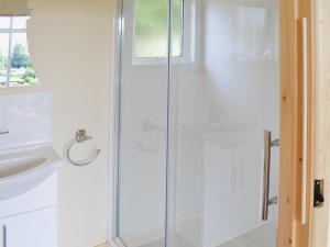 una ducha con una puerta de cristal junto a un lavabo en Blue Skies - 30260, en Cromer