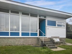 una casa con una puerta azul y un banco en Blue Skies - 30260, en Cromer 7 fotos más