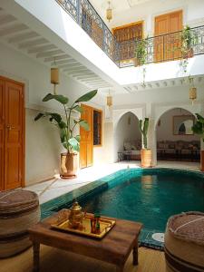 una gran piscina con una mesa en una habitación en Riad DabaKech, en Marrakech
