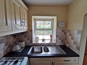 a kitchen with a sink and a window at Charlie's House Relaxing Farmhouse near Letterkenny  +24 photos