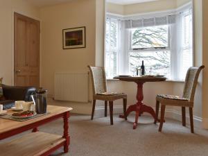 a living room with a table and chairs and a window at The Garden Apartment - Uk32517 in Whitby