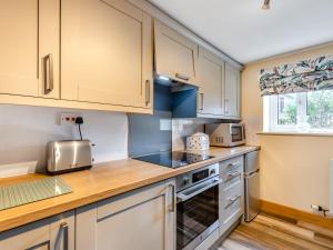 a kitchen with white cabinets and a counter top at Turnip House - Uk48909 in Allonby