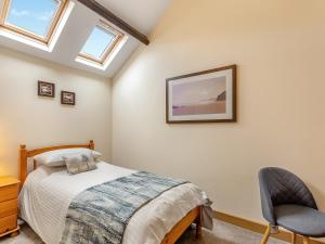 a bedroom with a bed and a chair at Turnip House - Uk48909 in Allonby +9 photos