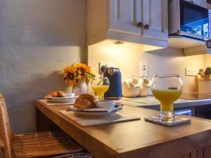 Una encimera de cocina con una mesa con dos vasos de zumo de naranja. en Granary Cottage, en Kirkby Malham 6 fotos más