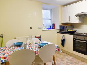 a kitchen with a table and chairs in a kitchen at Woodville in Porthmadog