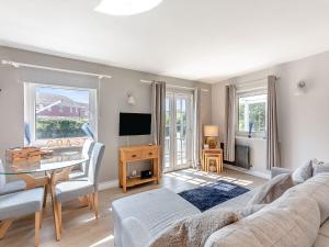 a living room with a couch and a table at Water's Edge Holiday Home in Beadnell