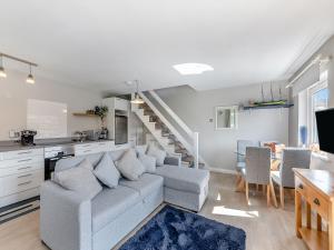 a living room with a couch and a kitchen at Water's Edge Holiday Home in Beadnell