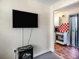 a living room with a flat screen tv on a wall at Rainbow Bungalow 2 - Uk39810 in Chapel Saint Leonards