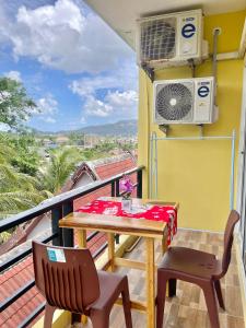 a balcony with a table and chairs and a fan at Pluemjai mansion in Ban Kathu