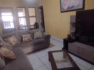 a living room with a couch and a flat screen tv at Casa na área central com 3 quartos in São Pedro