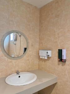 a bathroom with a sink and a mirror at Pluemjai mansion in Ban Kathu