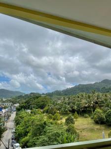 a view from a window of a street with palm trees at Pluemjai mansion in Ban Kathu